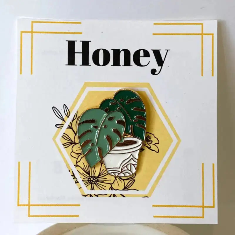Pin with plant design and 'Honey' text on a white background