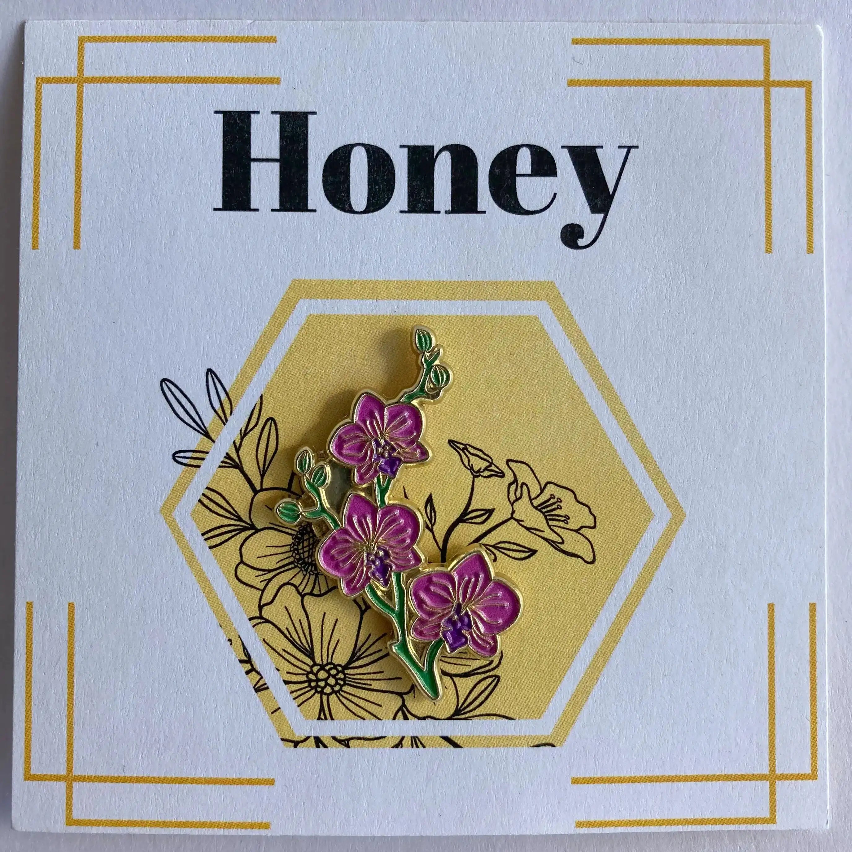 Floral pin on a card with 'Honey' text