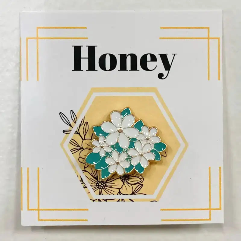 Floral brooch on a card with 'Honey' text