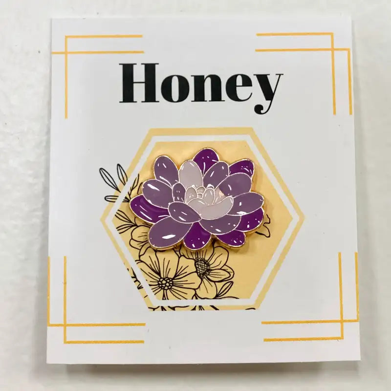 Purple flower pin on a card with 'Honey' text