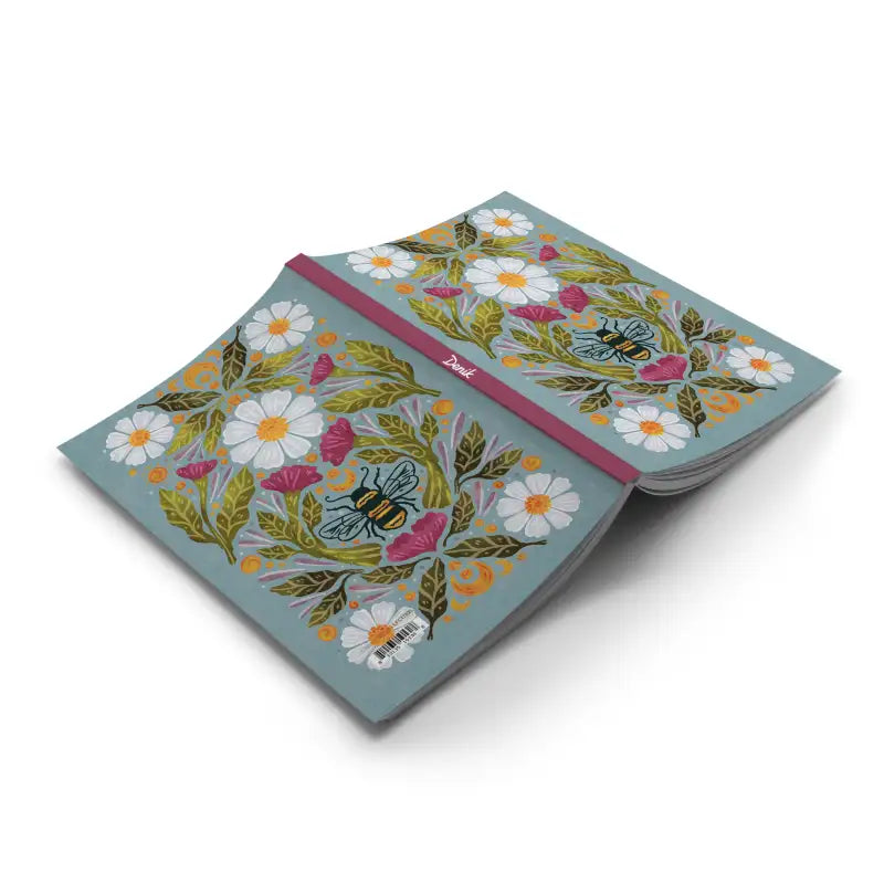 Notebook with floral design and bee illustration on a white background