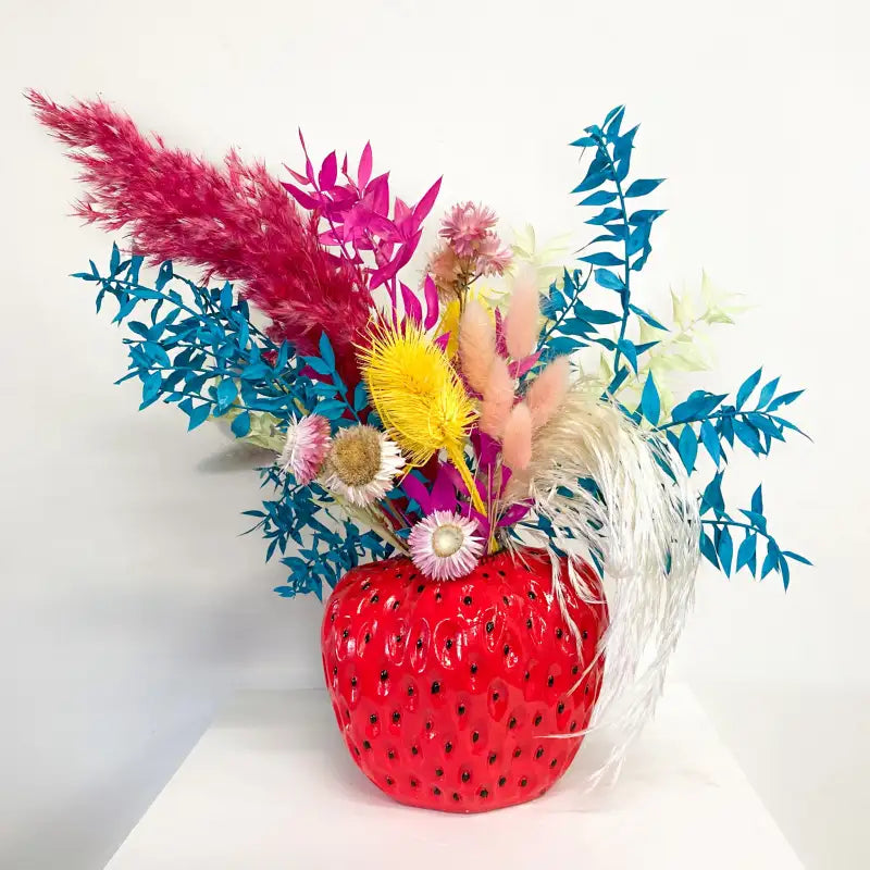 Colorful bouquet of flowers in a red vase on a white background