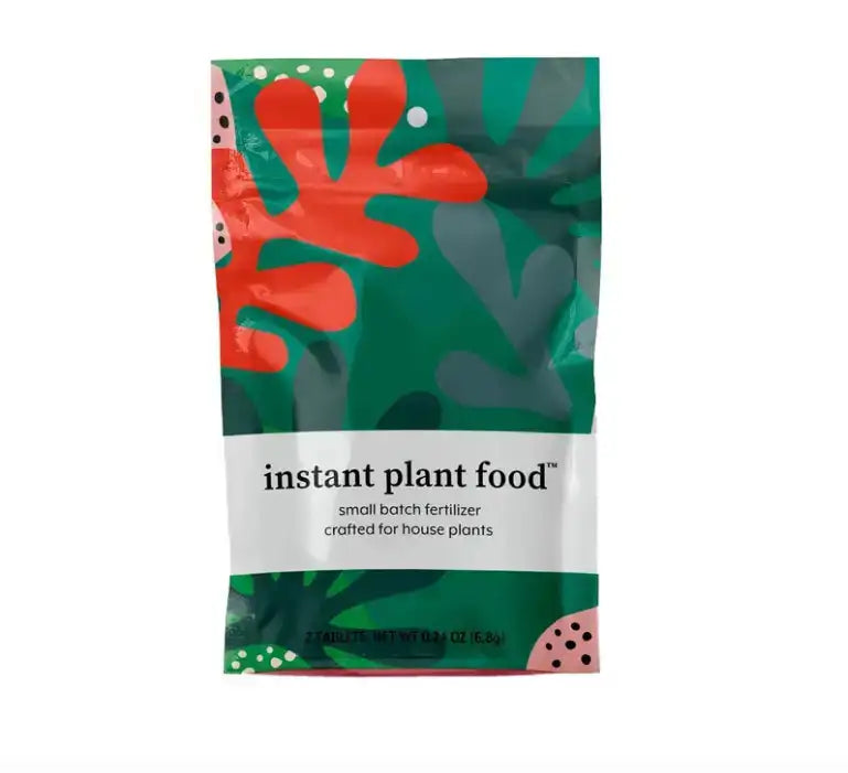Packaging of instant plant food with colorful leaf design on a white background