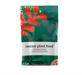 Packaging of instant plant food with colorful leaf design on a white background