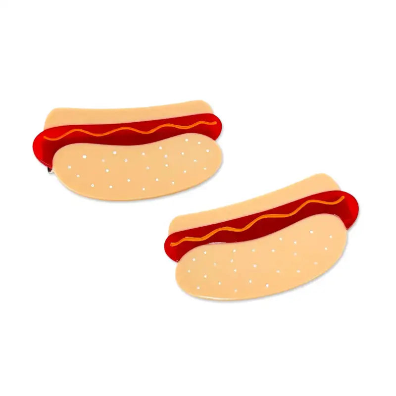 Two hot dogs hair clips with buns and ketchup on a white background
