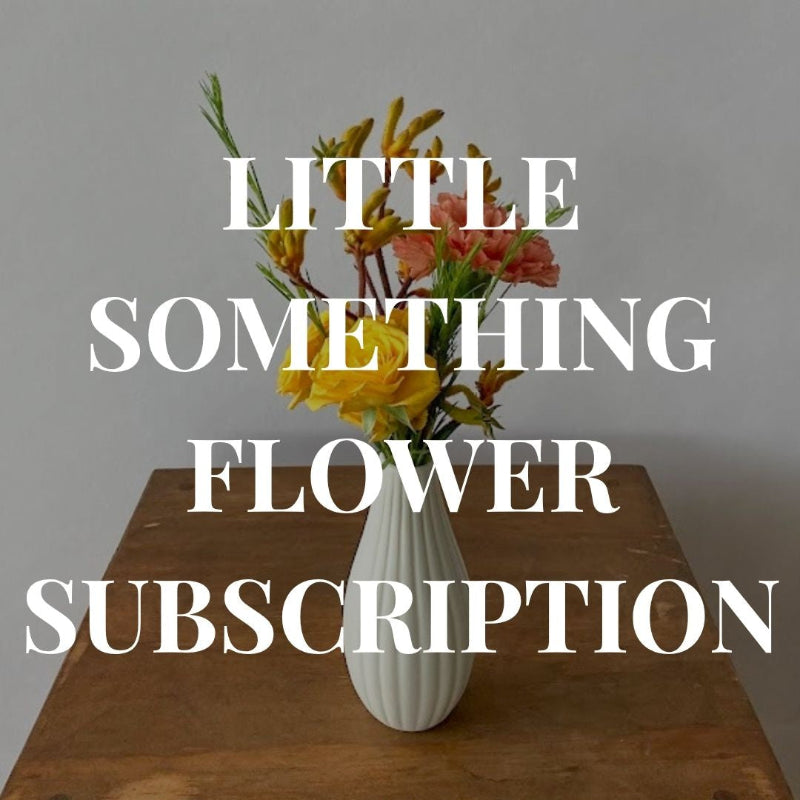 Floral arrangement in a white vase on a wooden table with text overlay.