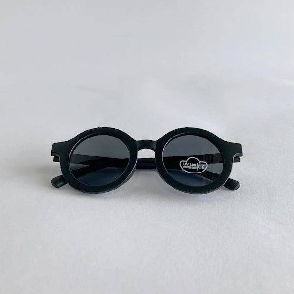Black kids sunglasses with a brand logo on a light gray background