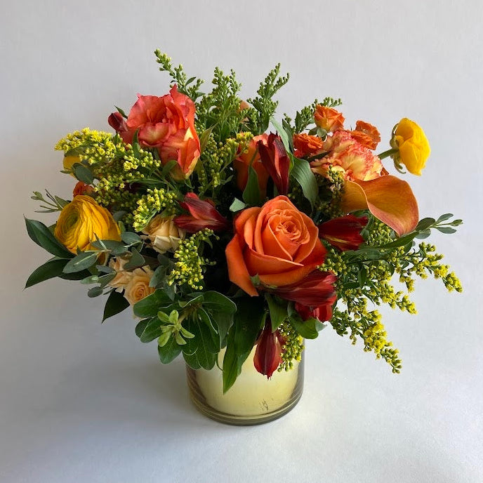 Live Like Luke Flower Arrangement with orange and yellow flowers in a gold vase