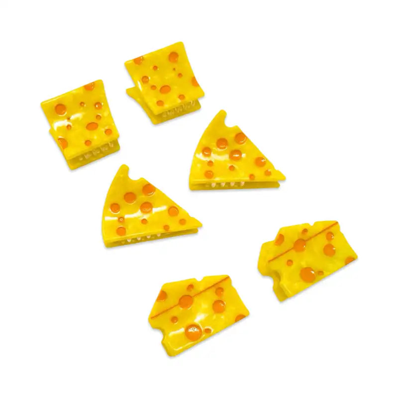 Set of yellow cheese slices with orange dots on a white background