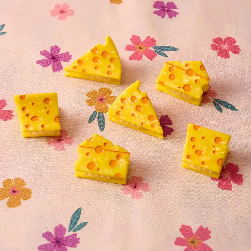 Yellow cheese-shaped hair clip on a pink floral background