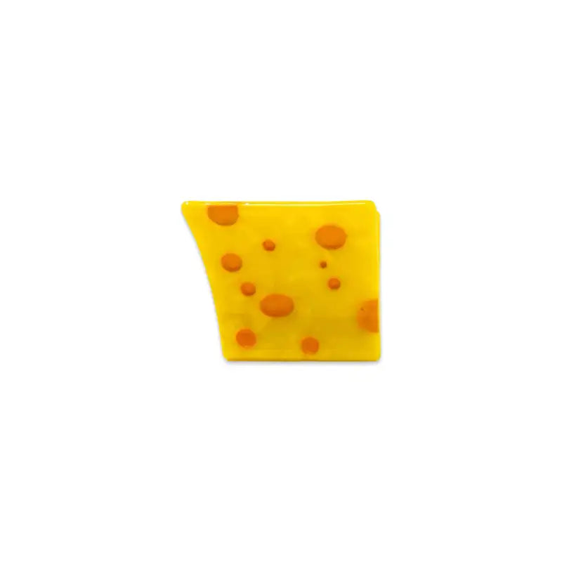 Yellow cheese wedge clip with brown spots on a white background