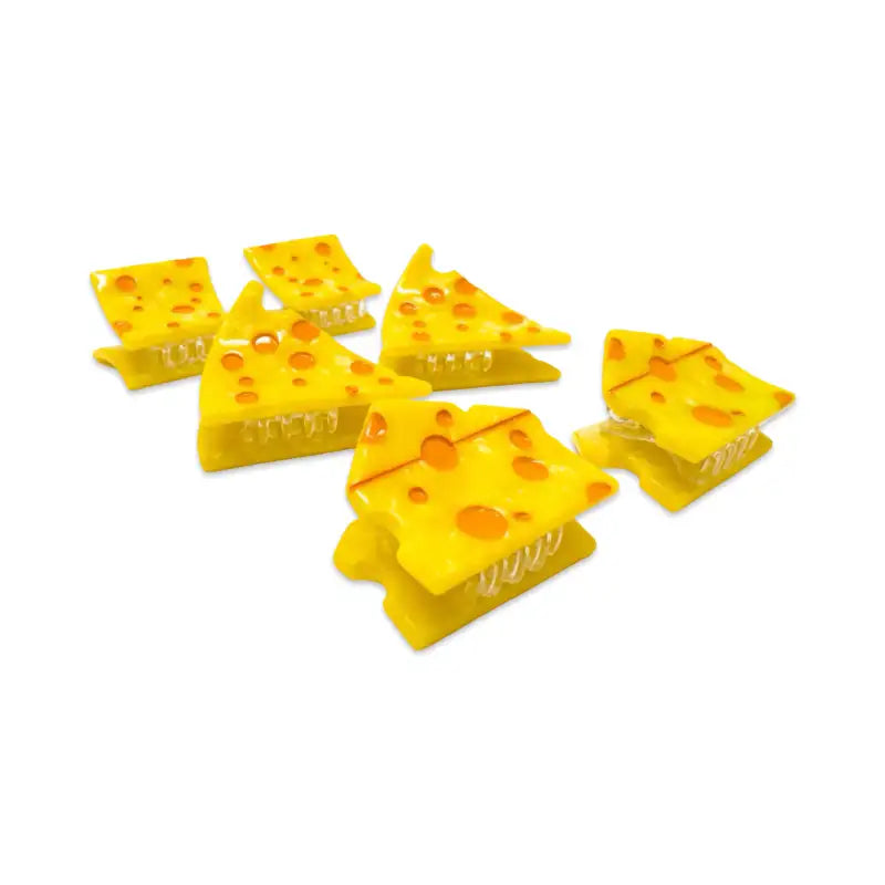 Set of yellow cheese-shaped clips on a white background