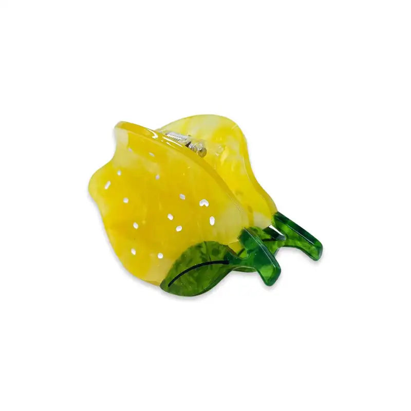 Lemon-shaped hair clip with green stem on a white background