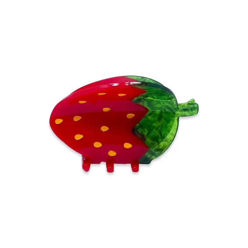 Colorful plastic hair claw like a strawberry with a green leaf on a white background