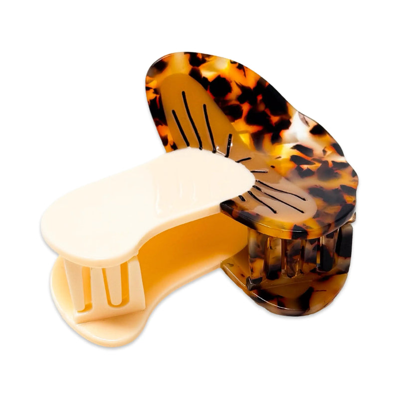 Tortoiseshell and beige hair clip on a white background