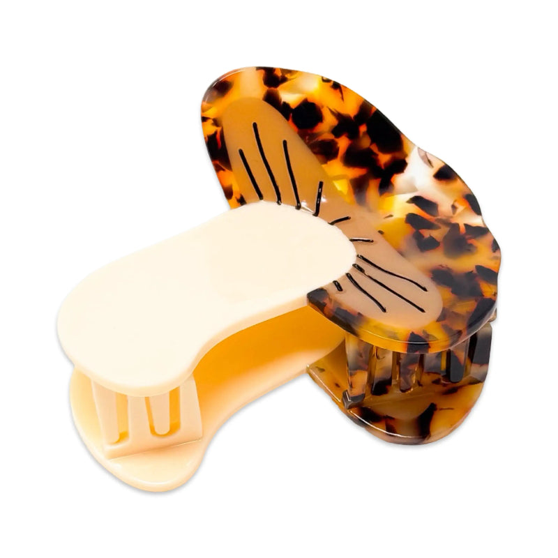 Tortoiseshell and beige hair clip on a white background