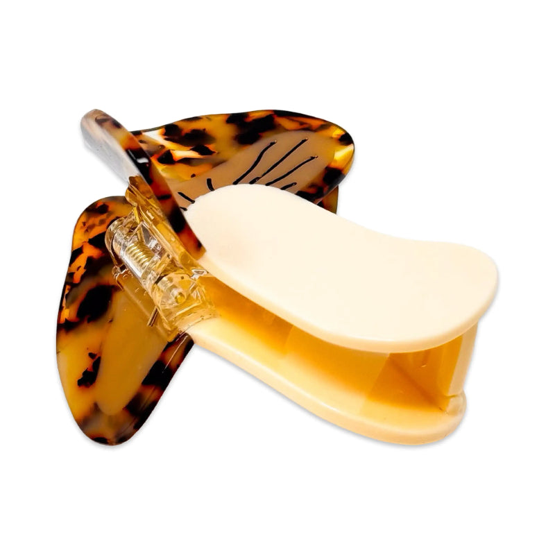 Tortoiseshell hair clip with a beige center on a white background