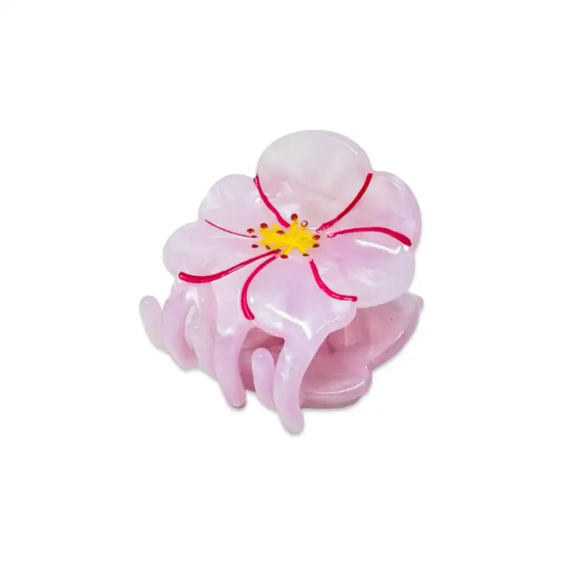 Pink flower-shaped hair clip on a white background