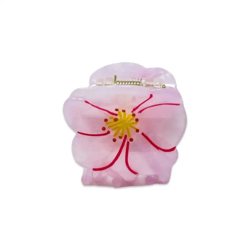 Pink flower-shaped hair clip on a white background