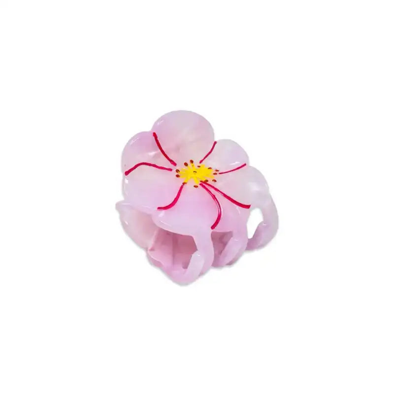 Pink flower-shaped hair clip on a white background