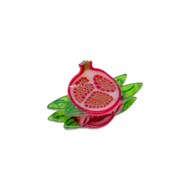 Pomegranate-shaped hair clip with green leaves on a white background