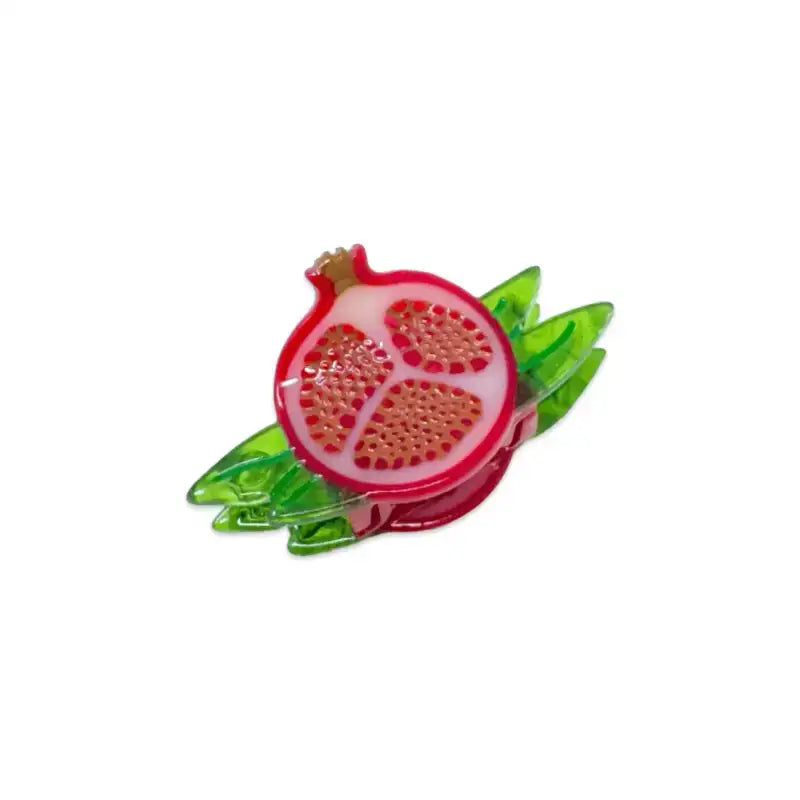 Pomegranate-shaped hair clip with green leaves on a white background