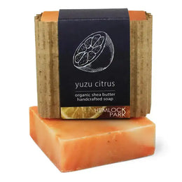 Two bars of soap, one stacked on top of the other, with a label indicating 'yuzu citrus' and 'organic shea butter'.