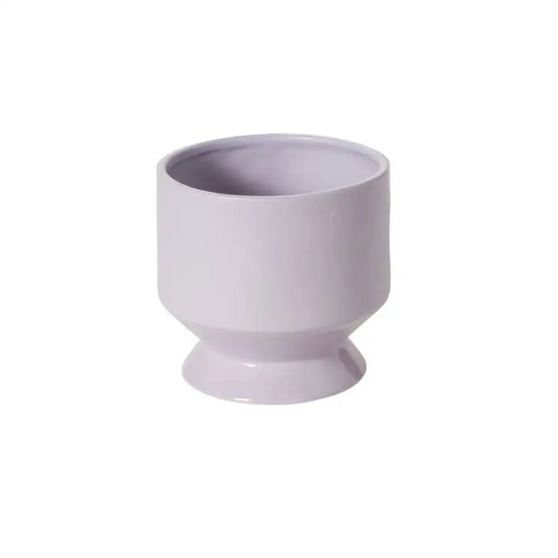 Light purple ceramic footed cup on a white background