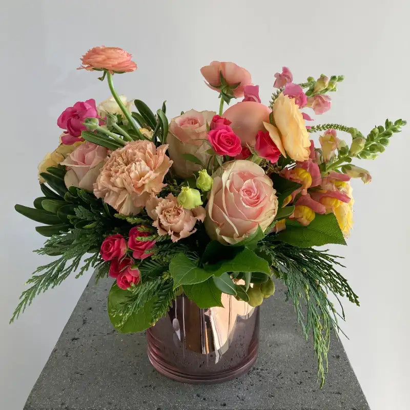 Bouquet of flowers in a vase on a gray surface with a light gray background