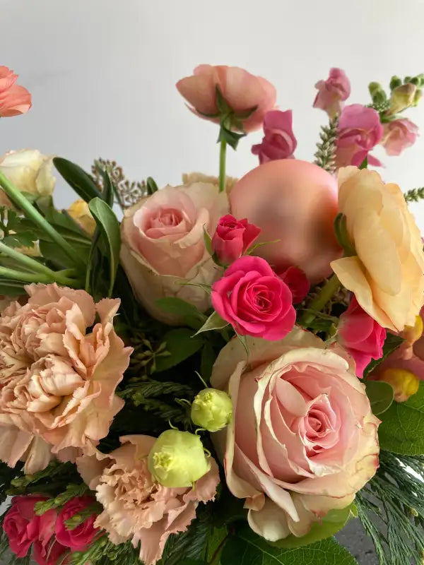 Bouquet of colorful flowers including roses and carnations on a light background