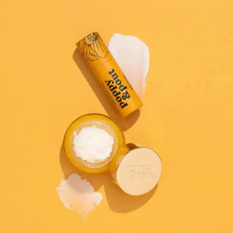 Yellow lip balm and container with 'Poppy & Root' branding on a yellow background