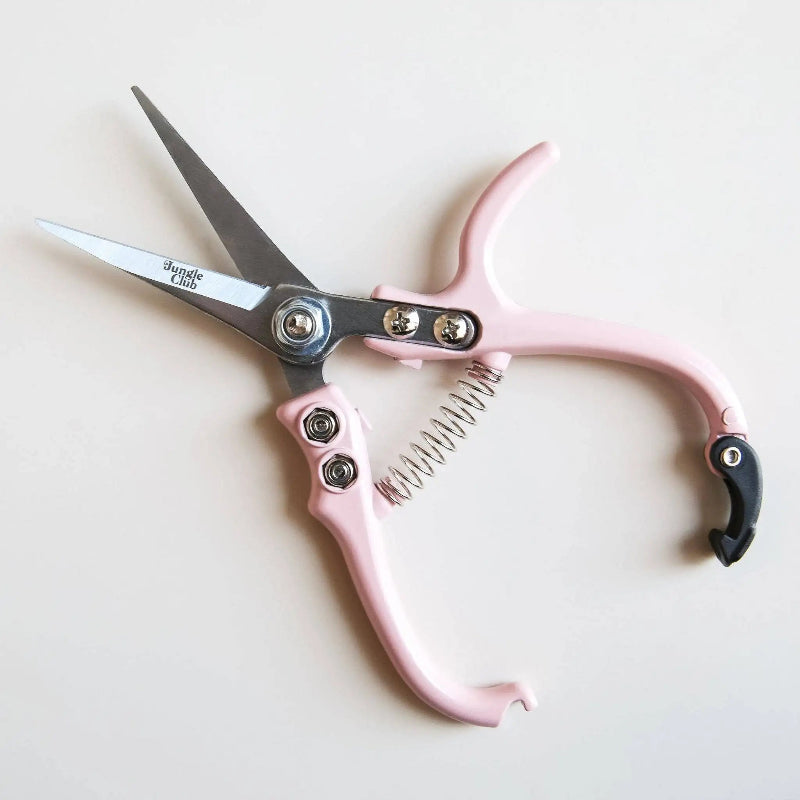 Pink-handled scissors with silver blades on a light background