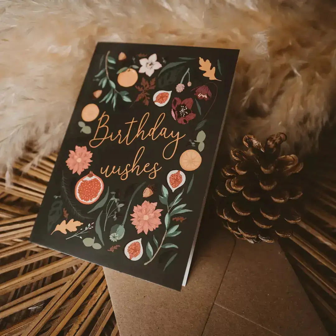 Greeting card with floral design and 'Birthday wishes' text on a textured surface.