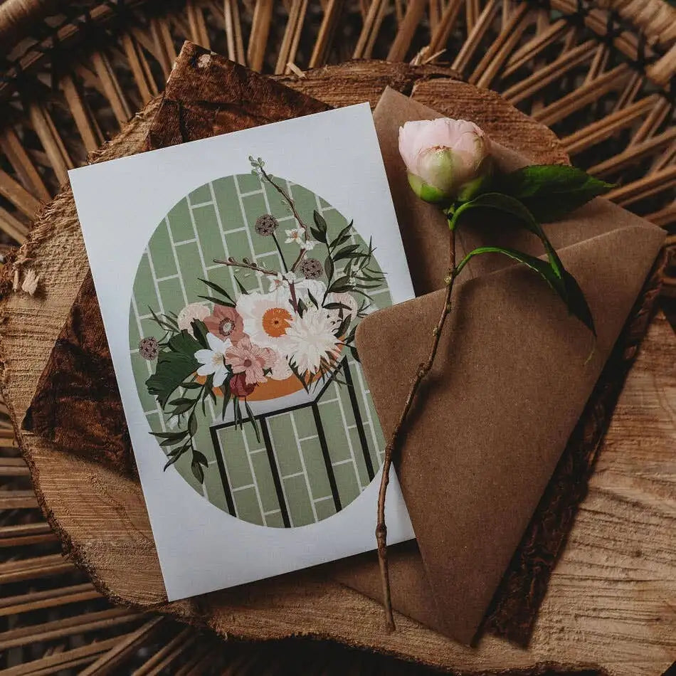 Greeting card with floral design and brown envelope on woven surface