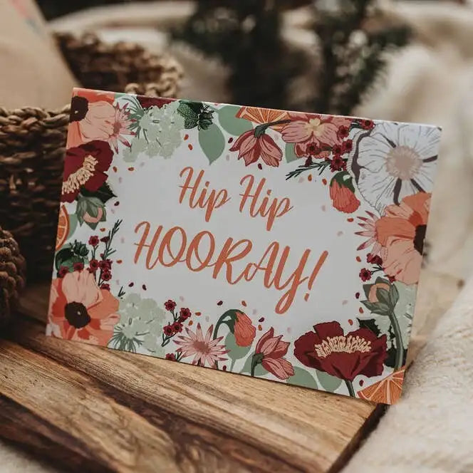 Floral card with 'Hip Hip Hooray!' text on a wooden surface