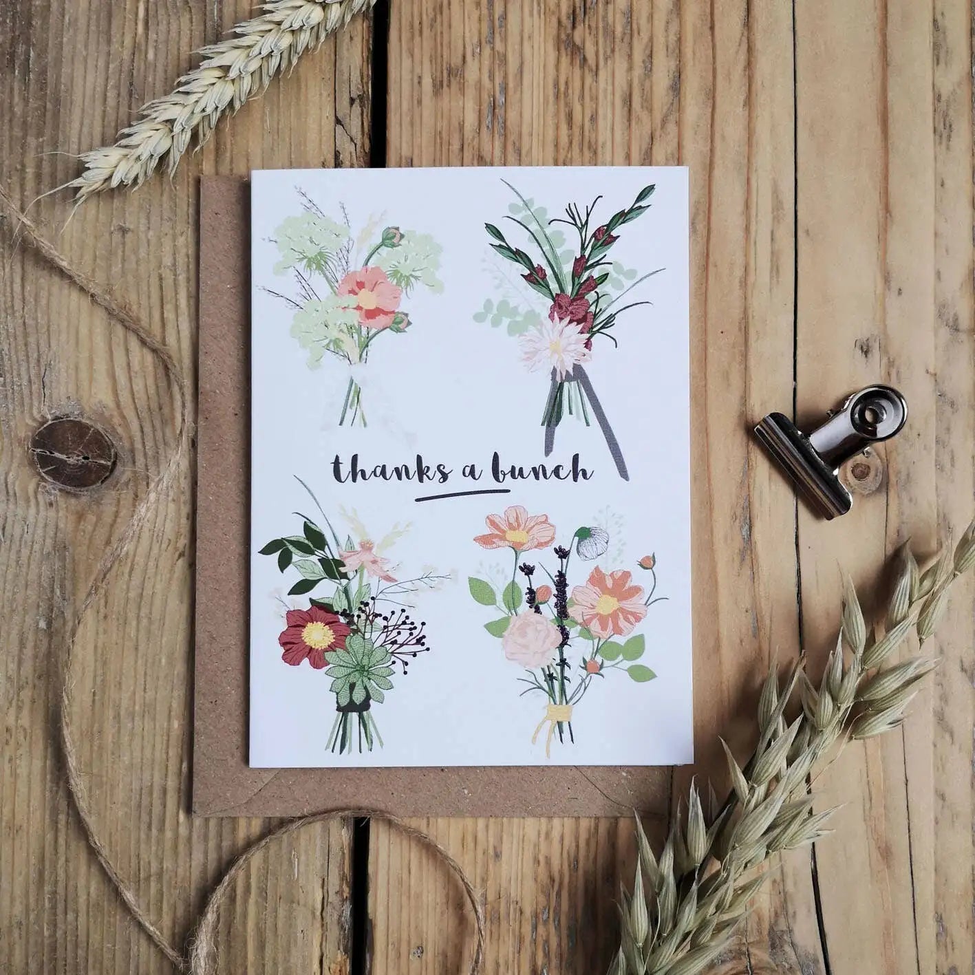 Greeting card with floral designs and 'thanks a bunch' text on a wooden surface.