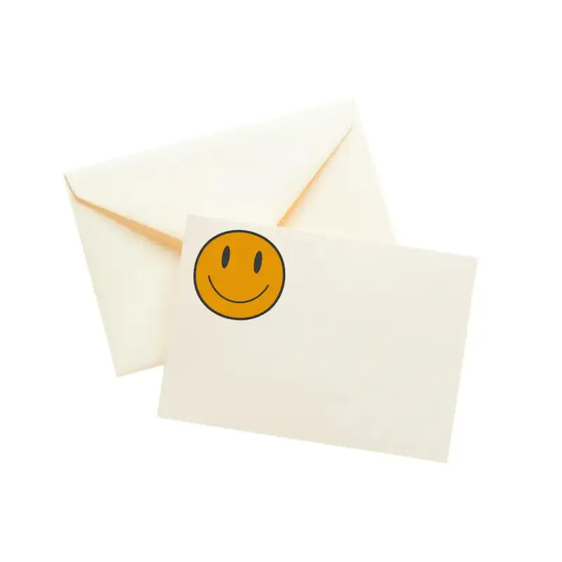 Smiley face sticker on a white card with a white envelope