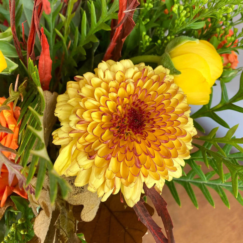 Bouquet of flowers with a prominent yellow flower in the center.