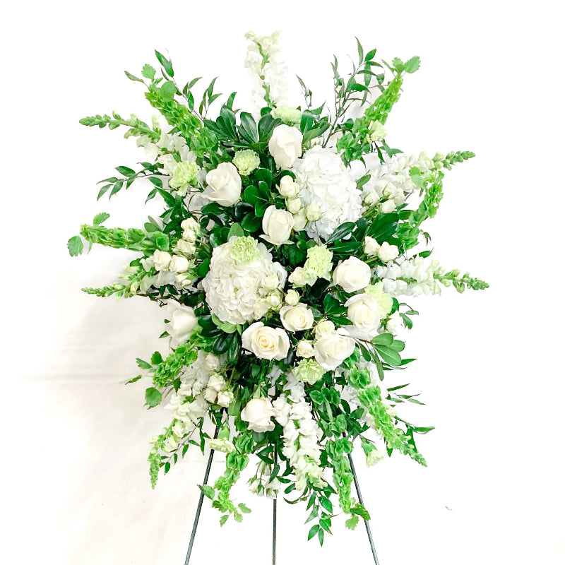 Floral arrangement with white flowers and green leaves on a white background
