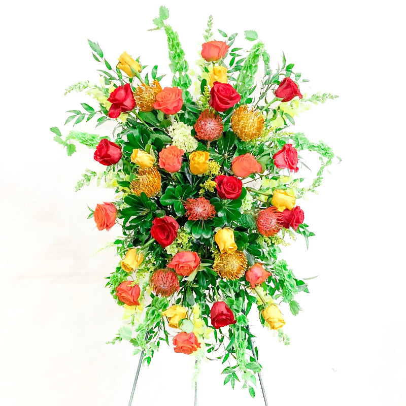Colorful floral arrangement with red, yellow, and green flowers on a white background
