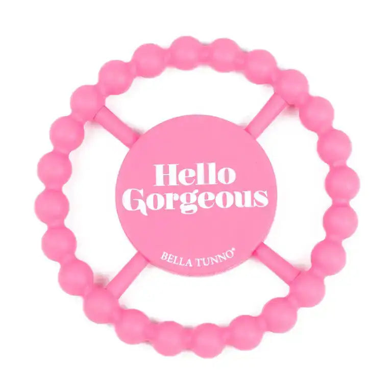 Pink teething ring with 'Hello Gorgeous' and 'Bella Tunno' text on a white background
