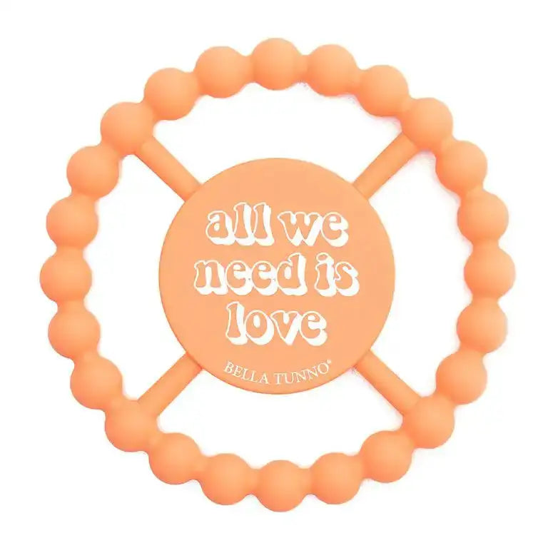 Orange teething ring with 'all we need is love' text and Bella Tunno logo on a white background