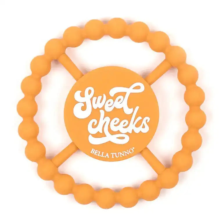 Orange teething ring with 'Sweet Cheeks' and 'Bella Tunno' text on a white background