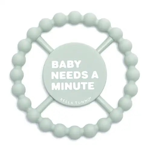 Teething ring with 'Baby Needs a Minute' text on a white background