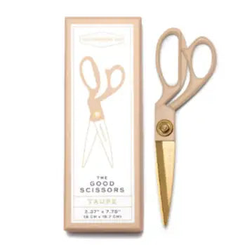Gold scissors with a matching box on a white background