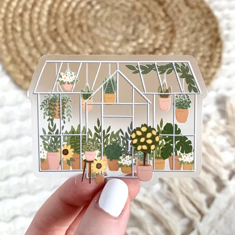 Card with illustration of a greenhouse filled with plants held by a hand.