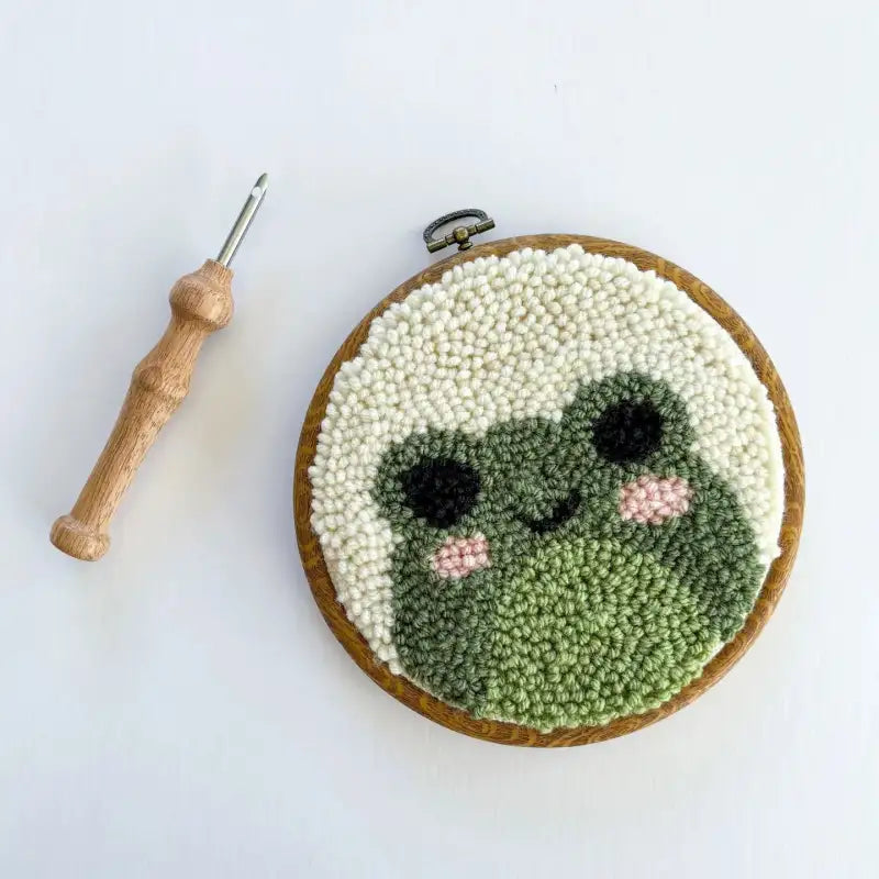 Embroidery hoop with a face design made of yarn on a white background