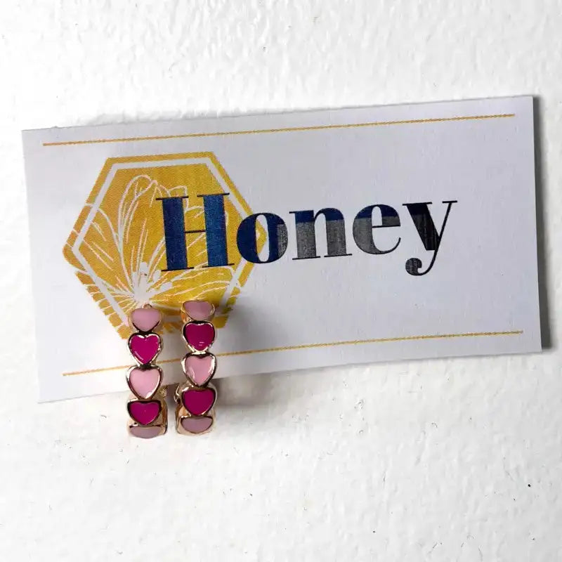 Heart-shaped earrings on a card with 'Honey' text against a white background