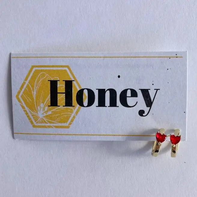 Heart-shaped earrings on a card with 'Honey' text and honeycomb design.