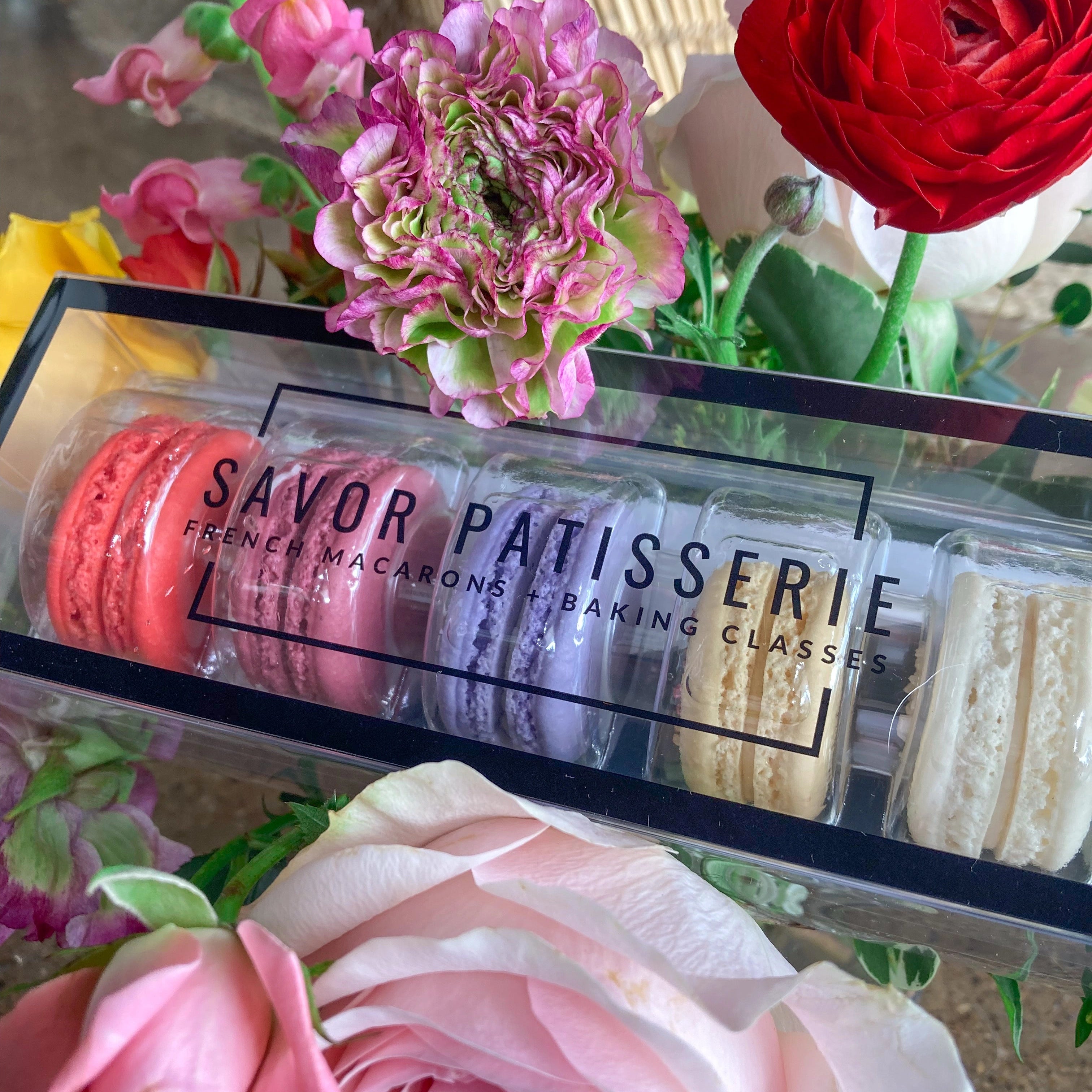 Box of macarons with flowers in the foreground